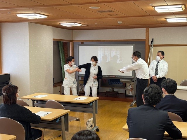 腕をつかまれた際の護身術を実演している職員たちの様子です。 職員が腕をつかまれた状態で防御の動作を取っています。