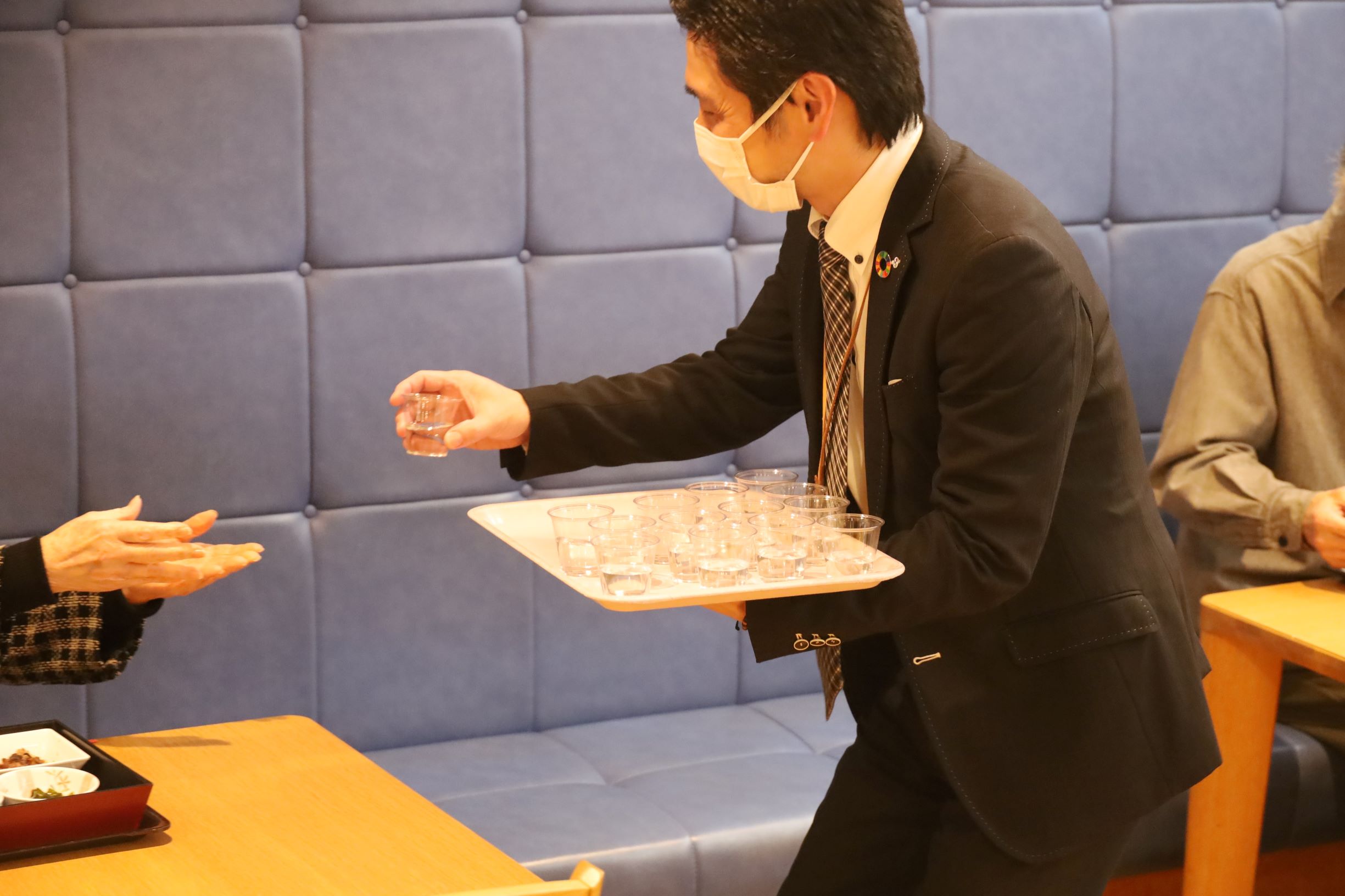 園長が祝い酒をお配りする様子